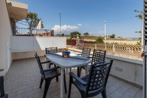 a patio with a table and chairs on a balcony at Villa Vani - Appartamento 1 in Marina di Ragusa