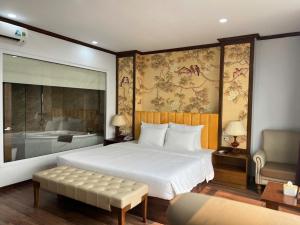 a bedroom with a large bed and a bath tub at Hanoi Central Westlake Hotel in Hanoi