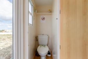a toilet in a small bathroom with a window at Bungalow Azul Profundo in Palmela +18 photos