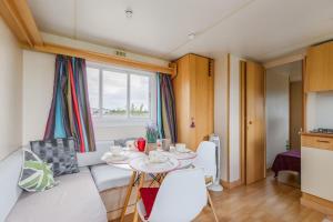 a small living room with a table and a couch at Bungalow Azul Profundo in Palmela