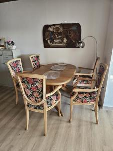 a dining room table with four chairs and a lamp at Ferienwohnung Unter Linden in Bad Bocklet +6 photos