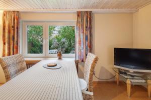 ein Esszimmer mit einem Tisch und einem Fernseher in der Unterkunft Ferienwohnung Schwalm - Aue in Neuental