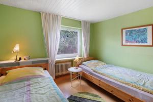 ein Schlafzimmer mit zwei Betten und einem Fenster in der Unterkunft Ferienwohnung Schwalm - Aue in Neuental