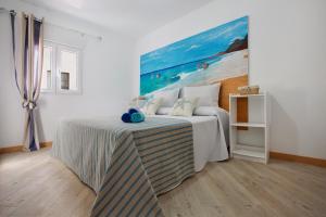 a bedroom with a bed with a painting on the wall at Holidays Maxorata Relax in Gran Tarajal