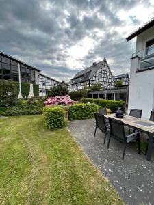 a patio with a table and chairs in a yard at Ferienhof Riekeshof in Schmallenberg