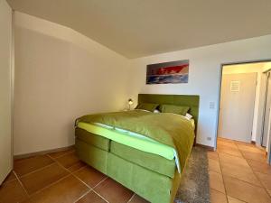 a bedroom with a green bed in a room at 208 im Lord Nelson in Cuxhaven