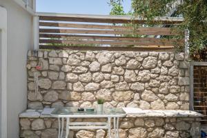 a stone wall with a table in front of it at Stathis Suite in Exanthia