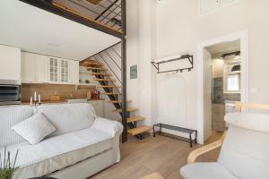 a living room with a white couch and a staircase at Stathis Suite in Exanthia