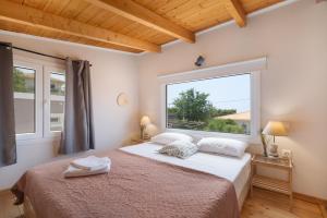 a bedroom with a bed and a large window at Stathis Suite in Exanthia +15 photos
