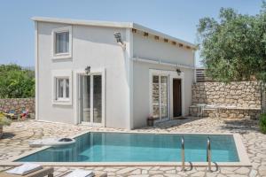 a villa with a swimming pool in front of a house at Stathis Suite in Exanthia