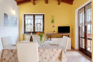 a dining room with a table with white chairs and a tableablish at Intelvi House in Castiglione dʼIntelvi