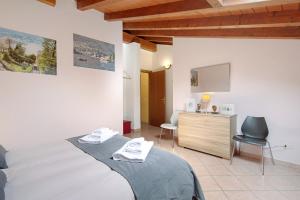 a bedroom with a bed and a desk and a television at Intelvi House in Castiglione dʼIntelvi