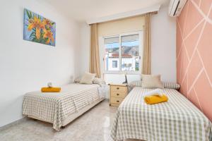 a bedroom with two beds and a window at Casa Ramos Con Jacuzzi in Nerja