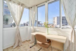 a desk in a room with windows with a vase of flowers at Casa Ramos Con Jacuzzi in Nerja