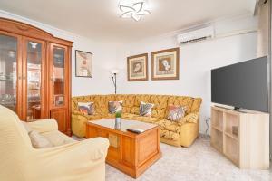 a living room with a couch and a flat screen tv at Casa Ramos Con Jacuzzi in Nerja