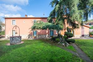 a house with a large tree in the yard at Bella Toscana Relax in Monsummano Terme