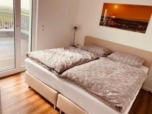 a bed in a room with a large window at Moin Mehrblick in Schillig
