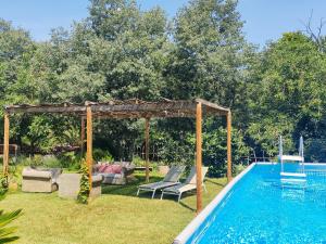a pool with a gazebo and chairs next to a swimming pool at La Pallissa - Can Bonet in Sant Martí Vell