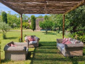 two couches sitting under a pergola in a yard at La Pallissa - Can Bonet in Sant Martí Vell