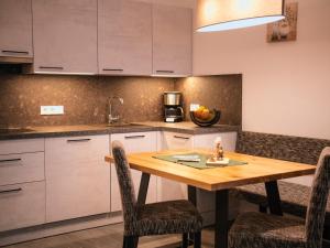 a kitchen with a wooden table and chairs at Zum Sonnentor App Pinus in Lutago +15 photos