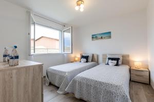 a bedroom with two beds and a window at Villa bassin d´archachon in Arès +18 photos