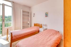 two beds in a room with a window at Chambre double à Toulouse in Toulouse
