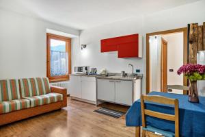 a kitchen and living room with a table and a couch at Appartamenti Ride Home in Commezzadura