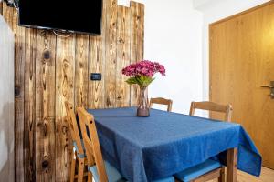 a blue table with a vase of flowers on it at Appartamenti Ride Home in Commezzadura