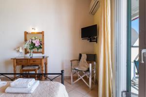 a bedroom with a bed and a desk with a mirror at Apostolos Apartment 4 in Póndi