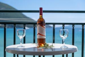 a bottle of wine and two wine glasses on a table at Apostolos Apartment 4 in Póndi +19 photos