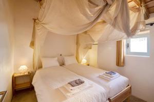 a bedroom with a white bed with a canopy at Casa Burro in Moncarapacho +17 photos