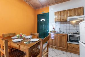 a kitchen with a wooden table and a green door at Apostolos Apartment 4 in Póndi