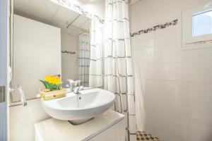 a white bathroom with a sink and a mirror at Fantastic in Can Picafort +20 photos