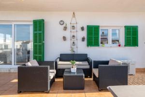 a patio with chairs and green shuttered windows at Fantastic in Can Picafort