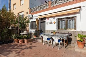 a patio with a black and white table and chairs at Villa Julia in Rubí
