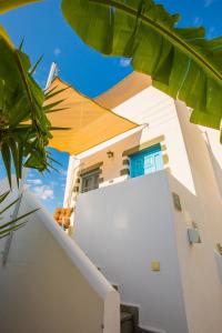 a white house with an umbrella on the side of it at Pico Bello Patmos 24 in Patmos