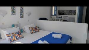 a bedroom with a bed with blue sheets and pillows at Pico Bello Patmos 24 in Patmos