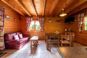 a living room with a red couch and a table at Chalet indépendant 3 personnes in Alex