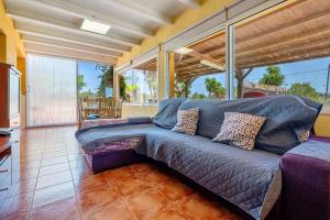 a large blue couch in a living room with windows at Can Boquera in L'Ametlla de Mar