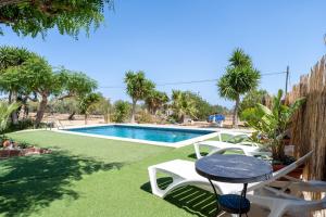 a patio with a table and chairs next to a swimming pool at Can Boquera in L'Ametlla de Mar