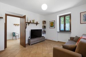 a living room with a couch and a television at La Casa Sul Lago in Osiglia