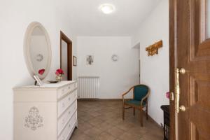 a bathroom with a dresser with a mirror and a chair at La Casa Sul Lago in Osiglia +26 photos