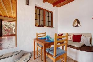 a dining room with a table and chairs and a bed at Yukalele 2 in Lajares