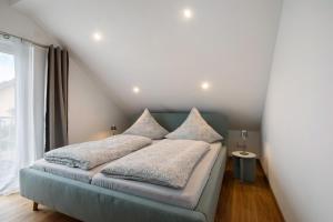 a bedroom with a bed with pillows on it at Ferienwohnung 6 in Bad Ditzenbach