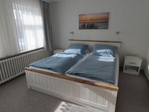 a bedroom with a bed with blue pillows on it at Große Warf mit Rasenfläche in Ockholm