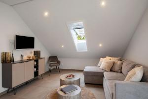 a living room with a couch and a tv at Ferienwohnung 6 in Bad Ditzenbach