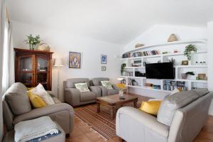 a living room with two couches and a tv at Casa Carmen - Comfort and Privacy in Nazaret