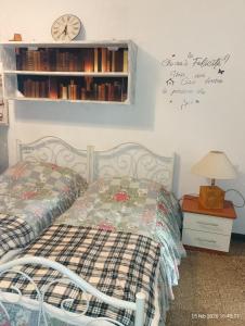 a bedroom with two beds and a book shelf at La Vista Sul Castello in Compiano