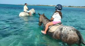 a young girl riding a horse in the water at Areon - Central Coastal Residence in Porto Cesareo