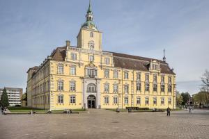 a large yellow building with a clock tower at Ferienhaus Inge in Oldenburg